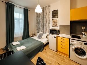a small room with a bed and a washing machine at Savor Apartment in Prague