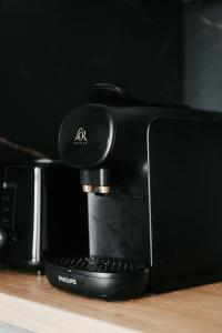 a black coffee machine sitting on a wooden table at Maison de campagne & SPA, Barbecue, Clim, WIFI 