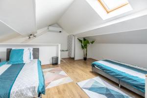 a attic bedroom with two beds and a skylight at Maison Althéa - Calme, Spa & Extérieur plein sud in Lempty +35 photos