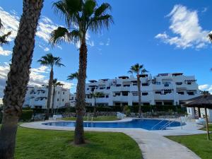 un complexe avec une piscine et des palmiers dans l'établissement Apartamento Vera Playa, à Vera