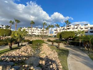 - une vue sur un complexe avec des palmiers et un sentier dans l'établissement Apartamento Vera Playa, à Vera