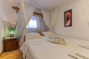 1 Schlafzimmer mit 2 weißen Betten und einem Fenster in der Unterkunft Holiday Home Captain's Village in Šljivovica