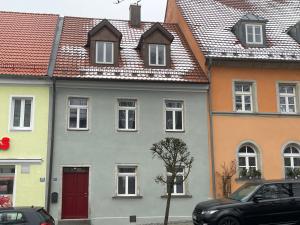 a group of houses with red doors and roofs at VOH Exklusives Wohnhaus MITTEN in Vohenstrauß, bis 8 Personen!!! in Vohenstrauß