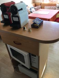 a wooden table with a microwave on top of it at Mobile home avec parking in Chorges +19 photos