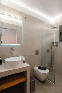 een badkamer met een wastafel, een toilet en een douche bij SKYROS BLUE SUITES in Skiros
