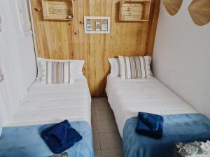 dwa łóżka w pokoju z drewnianymi ścianami w obiekcie GRAN CANARIA Oasis La Guancha w mieście Gáldar