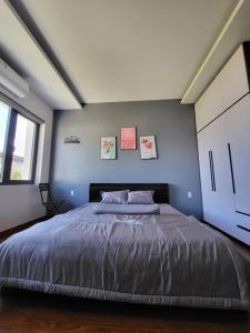 a bedroom with a large bed with blue walls at Nhà nguyên căn T Home BMT in Buon Ma Thuot