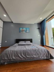 1 dormitorio con 1 cama grande en una habitación en Nhà nguyên căn T Home BMT en Buon Ma Thuot