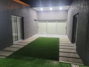 una habitación vacía con un césped verde en el medio en La cabala en General Alvear