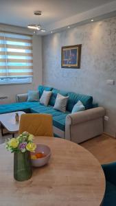a living room with a blue couch and a table at Vila Jahor Apartman Miro in Jahorina