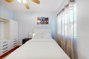 a white bedroom with a bed and a window at NEW! Stunning Peaceful Peoria Home - Very Close to Sports Complex in Peoria