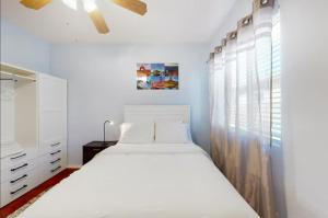 a white bedroom with a bed and a window at NEW! Stunning Peaceful Peoria Home - Very Close to Sports Complex in Peoria +17 photos