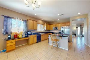 a large kitchen with wooden cabinets and a counter top at NEW! Stunning Peaceful Peoria Home - Very Close to Sports Complex in Peoria