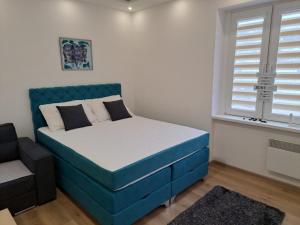 een kleine slaapkamer met een blauw bed en een raam bij Apartman Andrea in Sarajevo