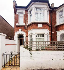 a brick house with a balcony and a gate at Jacuzzi Suite in London