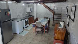 a kitchen with a long table with chairs and appliances at Casa espaçosa em Bento Gonçalves in Bento Gonçalves