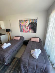 1 dormitorio con 2 camas y un cuadro en la pared en Double or 2-3 Beds Private Studio - PinkPanther en Buenos Aires