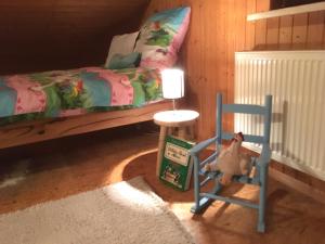 ein Schlafzimmer mit einem Bett und einem blauen Schaukelstuhl in der Unterkunft Kranich-Holzferienhaus 'Kleine Auszeit' in Rehden