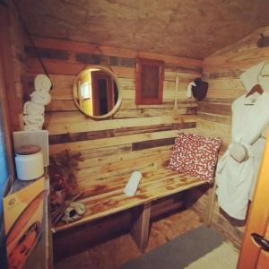 una camera con una parete in legno, una panca e uno specchio di Petit coin de paradis en pleine nature a Lantosque