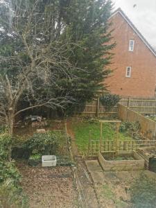 einen Garten vor einem Haus mit einem Baum in der Unterkunft Ella's Place in Luton