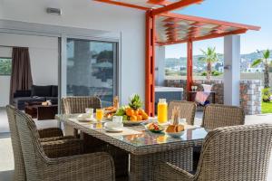 Villa Elite Kalathos by Villa Plus في كالاثوس: غرفة طعام مع طاولة مع فاكهة عليها