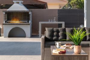 un patio con sofá y fogata en Villa Elite Kalathos by Villa Plus en Kalathos