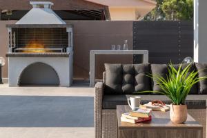 a patio with a couch and a fire pit at Villa Elite Kalathos by Villa Plus in Kalathos