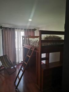 a bedroom with a bunk bed and two chairs at lindo y cómodo departamento familiar in Mexico City