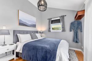 Un dormitorio con una cama y ventanas de color azul y blanco. en Wakefields - an enchanting mountain view cottage, en Mole Creek