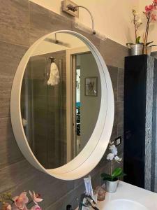 lavabo en el baño con un gran espejo ovalado en la pared en Milanese luxury apartment, en Milán