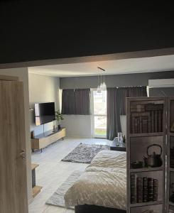 een slaapkamer met een bed en een televisie. bij Central Modern Apartment Volos in Volos