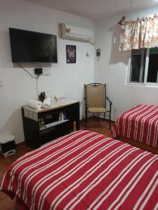 um quarto com 2 camas e uma televisão de ecrã plano em Mariposas Rooms em Cancún