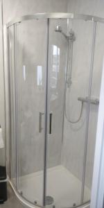 a shower with a glass door in a bathroom at Free Derry Apartments in Derry Londonderry