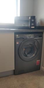 a washing machine with a microwave on top of it at Free Derry Apartments in Derry Londonderry