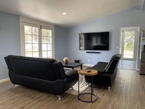 a living room with a black couch and a table at Temecula Rejuvenation in Temecula