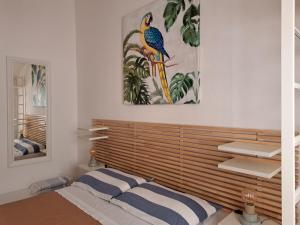 ピエンツァにあるLa Dimora Di Pienzaの木製のヘッドボードと壁画が備わるベッドルーム