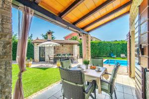 un patio con mesa, sillas y piscina en Villa Rustica Nicole by Villa Plus, en Štokovci