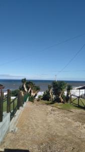una strada sterrata che conduce alla spiaggia con palme di Casa verde a Laguna