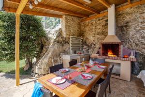 an outdoor dining area with a table and a fireplace at Villa Irines House by Villa Plus in Khromonastírion
