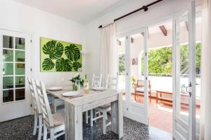 uma sala de jantar com uma mesa de madeira e cadeiras em Villa Can Sintes by Villa Plus em Es Mercadal