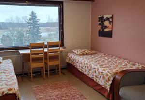a room with a bed and a desk and a window at Ingala in Inkoo