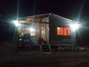 a small house at night with two lights at Cabañas La Frontera. in Puerto Natales