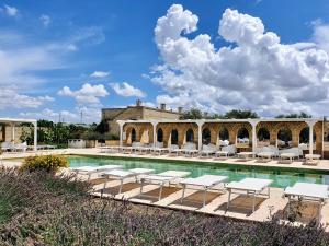 a pool with lounge chairs and a building at Masseria Agrituristica Lama San Giorgio in Rutigliano