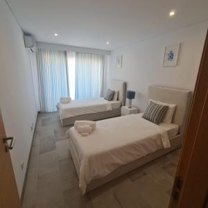 a living room with two beds and a couch at MARIACAST CLUBE DA PRAIA DA ROCHA in Portimão +16 photos