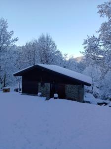 ein Gebäude mit einem schneebedeckten Dach im Schnee in der Unterkunft Petit coin de paradis en pleine nature in Lantosque