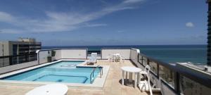 a balcony with a swimming pool and the ocean at Apartamento com vista para o Mar, e Piscina na cobertura in Recife