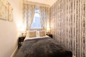 a bedroom with a bed with curtains and a window at Crosby Apartments in Liverpool