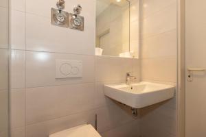 a white bathroom with a sink and a toilet at Strandstrasse-43-Wohnung-25-157 in Kühlungsborn