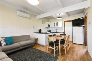 a living room with a couch and a table and a kitchen at Ocean Bridge Lakes Entrance in Lakes Entrance