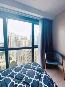 a bedroom with a bed and a large window at Eastwood High Life - Spectacular City View in Manila